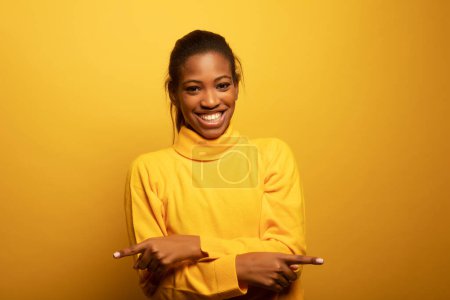 Téléchargez les photos : Gros plan portrait de belle jeune femme africaine riant sur fond jaune, style de vie et concept de personnes. - en image libre de droit