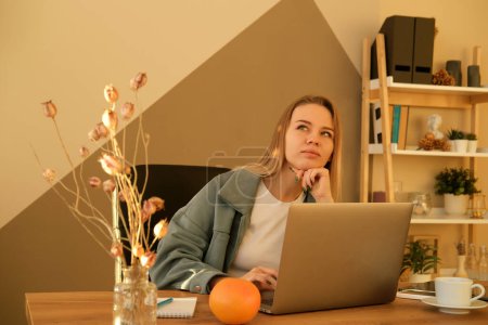 Téléchargez les photos : Jeune femme blonde habillée ordinateur portable de travail occasionnel. Femme d'affaires occupée à travailler sur ordinateur portable au bureau. - en image libre de droit