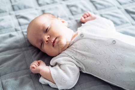 Photo for Little baby girl lying on a bed while sleeping - Royalty Free Image