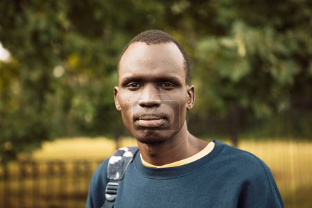 Foto de Un joven negro está caminando por el parque. Cierre el retrato. Hora de verano. - Imagen libre de derechos