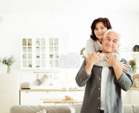 Photo for Portrait of cute happy Caucasian couple of retired husband and wife hugging indoors. Relationship, people and family concept. - Royalty Free Image