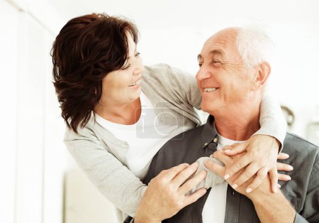 Photo for Portrait of cute happy Caucasian couple of retired husband and wife hugging indoors. Relationship, people and family concept. - Royalty Free Image