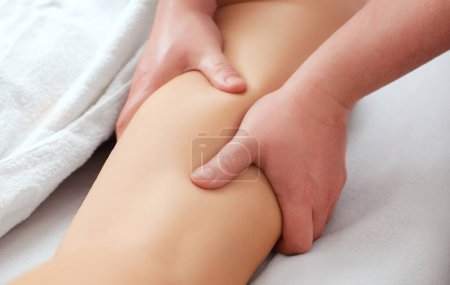 Foto de El masajista hace masaje anticelulítico en la nalga y los muslos del paciente. Tratamiento del exceso de peso. - Imagen libre de derechos