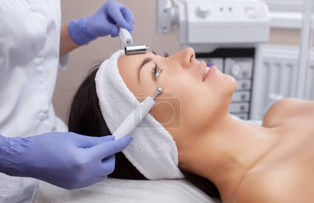 Photo for The cosmetologist makes the apparatus a procedure of Microcurrent therapy of a beautiful, young woman in a beauty salon. Cosmetology and professional skin care. - Royalty Free Image