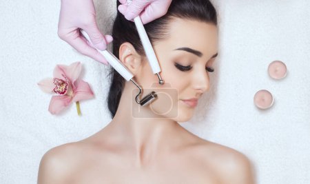Photo for The cosmetologist makes the apparatus a procedure of Microcurrent therapy of a beautiful, young woman in a beauty salon. Cosmetology and professional skin care. - Royalty Free Image