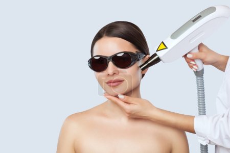 Téléchargez les photos : Procédure d'épluchage du visage en carbone dans un salon de beauté. Matériel traitement de cosmétologie. - en image libre de droit