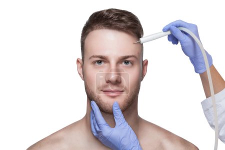 Photo for Men's cosmetology. Beautician makes a man a procedure to remove acne from his face. - Royalty Free Image