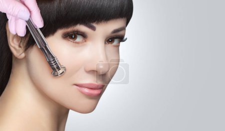 Photo for There is a woman, who is making the procedure Microdermabrasion of the facial skin in a beauty salon.Cosmetology and professional skin care. - Royalty Free Image