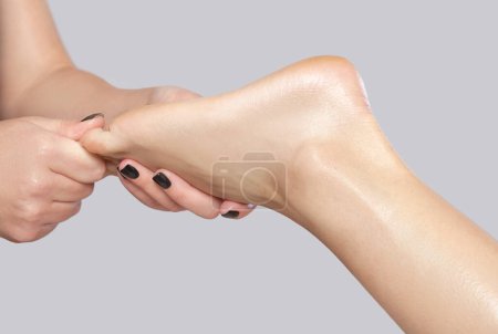 Téléchargez les photos : Un médecin orthopédique effectue un massage du pied et du bas de la jambe du patient après une blessure en clinique.. - en image libre de droit