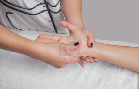 Téléchargez les photos : Un médecin orthopédique fait massage relaxant de la main et du bras du patient après à la clinique. Concept de cosmétologie et massage. - en image libre de droit