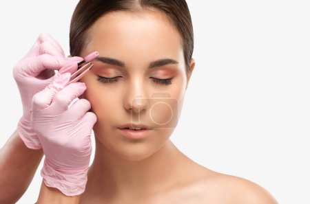 Maquillaje artista peina y arranca las cejas después de teñir en un salón de belleza. Maquillaje profesional y cosmetología cuidado de la piel.