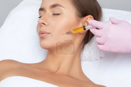Cosmetólogo hace prp terapia en la cara de una mujer hermosa en un salón de belleza. Concepto de cosmetología.