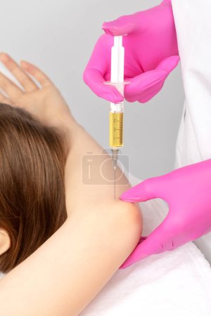 Photo for Doctor doing stem cell therapy on a patient's elbow after the injury. Treating knee pain with platelet-rich plasma injection. Treatment of arthritis and osteoarthritis.Medical and cosmetology concept. - Royalty Free Image