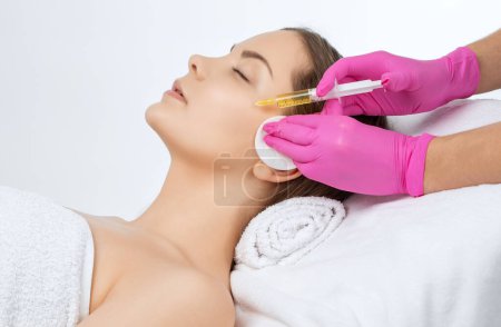 Cosmetologist does prp therapy on the face of a beautiful woman in a beauty salon. Cosmetology concept.