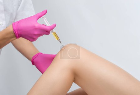 Arzt bei der Stammzellentherapie am Knie eines Patienten nach der Verletzung. Knieschmerzen mit plättchenreicher Plasmainjektion behandeln. Behandlung von Arthritis und Arthrose. Medizinisch-kosmetologisches Konzept.
