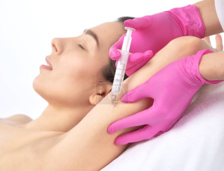 Ästhetische Kosmetikerin macht lipolytische Injektionen, um Fett am Arm und Körper einer Frau zu verbrennen. Weibliche ästhetische Kosmetologie im Schönheitssalon. Kosmetologie-Konzept.