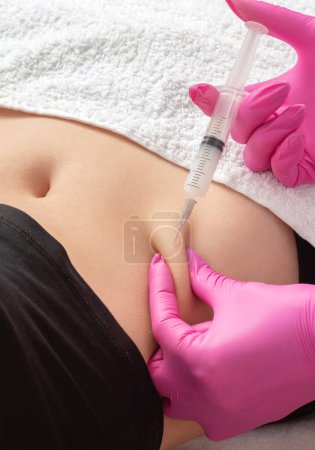 Doktor der ästhetischen Kosmetologie macht lipolytische Injektionen, um Körperfett auf Bauch und Körper einer Frau zu verbrennen. Weibliche ästhetische Kosmetik im Schönheitssalon.