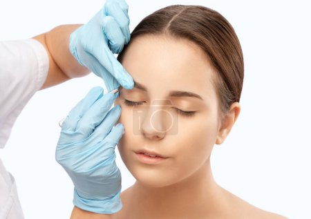Maskenbildner kämmt und zupft Augenbrauen nach dem Färben im Schönheitssalon. Professionelle Make-up und Kosmetologie Hautpflege.