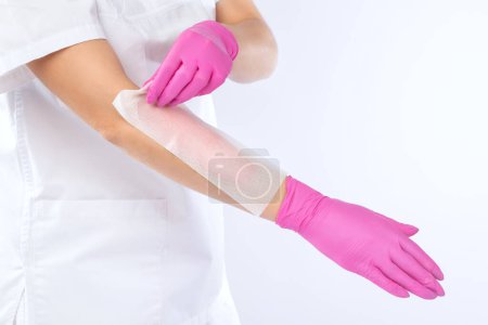 Foto de Una esteticista hace una depilación del brazo de una mujer en un salón de belleza. Cosmetología estética femenina. - Imagen libre de derechos