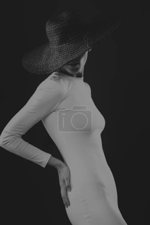 Téléchargez les photos : Elégante femme mince dans une robe blanche et chapeau noir. - en image libre de droit