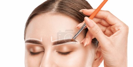 Maskenbildner zeichnet mit weißem Bleistift für Augenbrauen und malt Augenbrauen. Professionelles Make-up und Gesichtspflege.