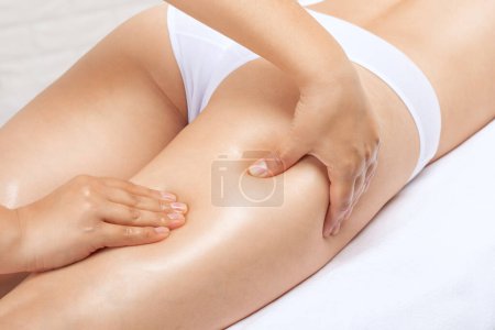 Masajista hace masaje anticelulítico en las piernas, muslos, caderas y nalgas en el spa. Tratamiento del sobrepeso, escultura corporal.Cosmetología y concepto de masaje.