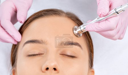 Téléchargez les photos : Procédure microdermabrasion sur le visage contre l'acné et les points noirs. Cosmétologie féminine dans le salon de beauté. - en image libre de droit