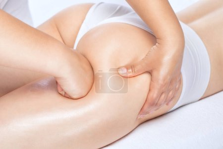 Masajista hace masaje anticelulítico en las piernas, muslos, caderas y nalgas en el spa. Tratamiento del sobrepeso, escultura corporal.Cosmetología y concepto de masaje.