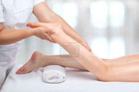 Der Masseur lässt die Beine, Schenkel, Hüften und Gesäß im Wellnessbereich gegen Cellulite massieren. Übergewichtsbehandlung, Körpermodellierung, Kosmetologie und Massagekonzept.