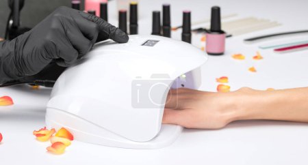 Photo for Coating nails with gel polish in the beauty salon. Professional care for hands. - Royalty Free Image