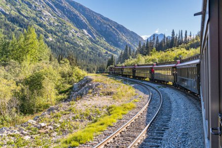 Téléchargez les photos : Skagway, AK - 7 septembre 2022 : Le train White Pass et Yukon Route serpente à travers les montagnes à l'est de Skagway. - en image libre de droit