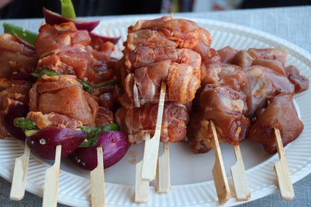 Porc meat with bacon on a wooden stick, ready to put on the barbcue