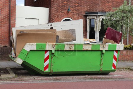 Loaded dumpster near a construction site, a home renovation or maintenance