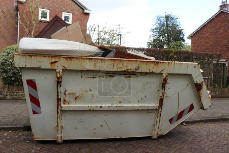 Beladener Müllcontainer in der Nähe einer Baustelle, einer Hausrenovierung oder Wartung