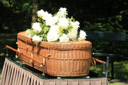 Un cercueil de saule de style écologique et contemporain sur un catafalque lors d'une cérémonie en plein air