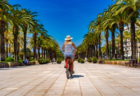 Frau fährt Fahrrad auf Strandboulevard Costa Dorada Spanien 