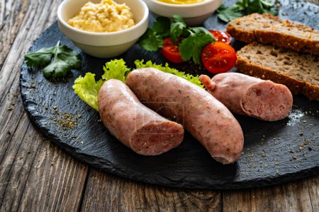 Easter breakfast - boiled white sausages, toasts and horseradish on wooden table