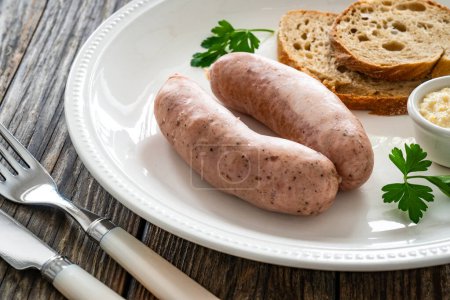 Petit déjeuner de Pâques - saucisses blanches bouillies, pain grillé et raifort sur table en bois 