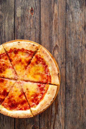 Margherita Pizza con salsa de tomate y queso mozzarella sobre fondo de madera 