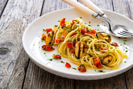 Spaghetti with mussels on wooden table 