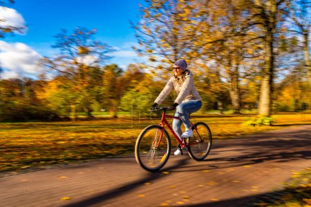 Bewegungsunschärfe. Frau fährt Fahrrad im Stadtpark