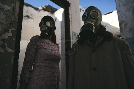 Photo for A woman and a man in a gas mask staying in destroyed building, low angle shot, good for book cover - Royalty Free Image