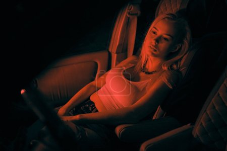 Photo for A beautiful girl of European appearance sits on the passenger seat in the car and looking to the window - Royalty Free Image