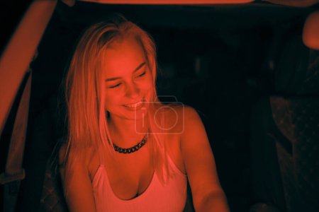 Foto de Una hermosa chica de aspecto europeo se sienta en el asiento del pasajero en el coche y mirando a la ventana - Imagen libre de derechos