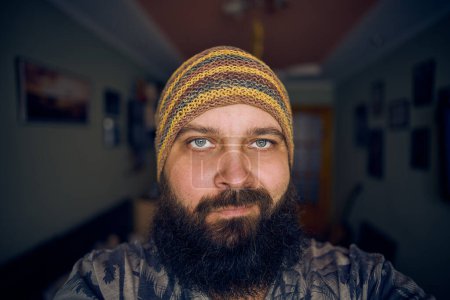 Foto de Un hombre con barba con sombrero y camisa a rayas, mirando a la cámara - Imagen libre de derechos