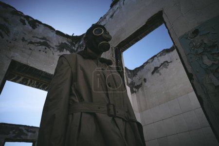 Photo for A man in gas mask walking inside an old building, low angle shot, good for book cover - Royalty Free Image