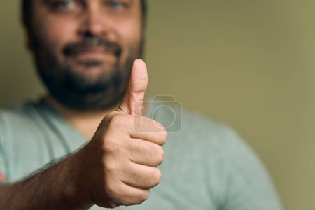Téléchargez les photos : Un homme européen barbu montre signe de main super - en image libre de droit