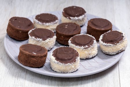 Téléchargez les photos : Bonbons au chocolat avec garniture à la crème vanille et copeaux de noix de coco - en image libre de droit