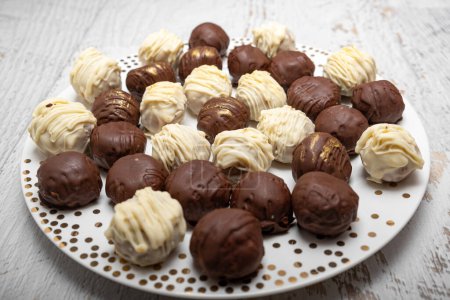 Photo for Chocolate truffles on plate on white table. Homemade. Praline bonbons. - Royalty Free Image