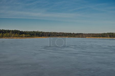 Photo for Lake partially covered with ice during sunny day in winter season - Royalty Free Image